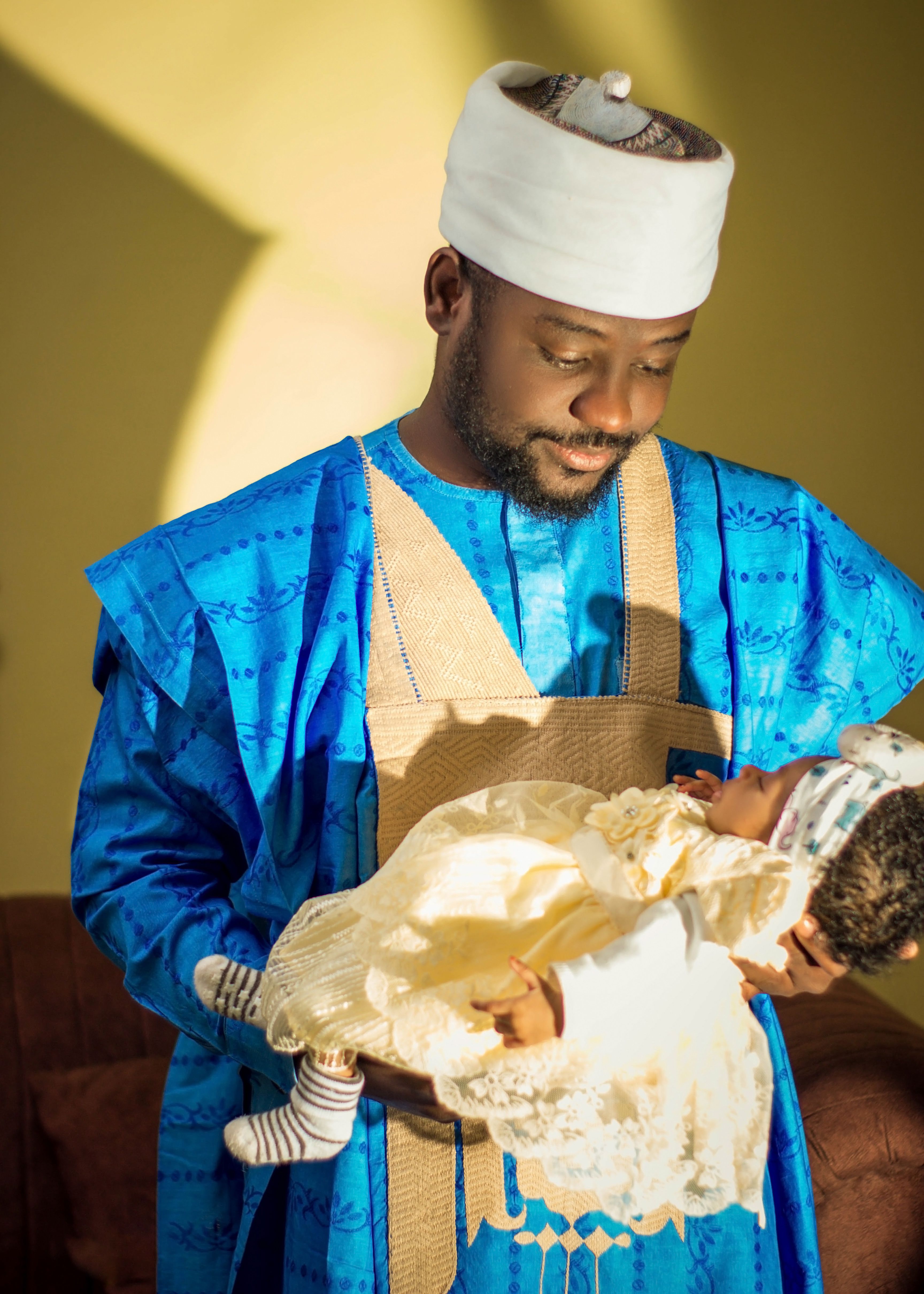 Father Holding Newborn in Traditional Attire · Free Stock Photo