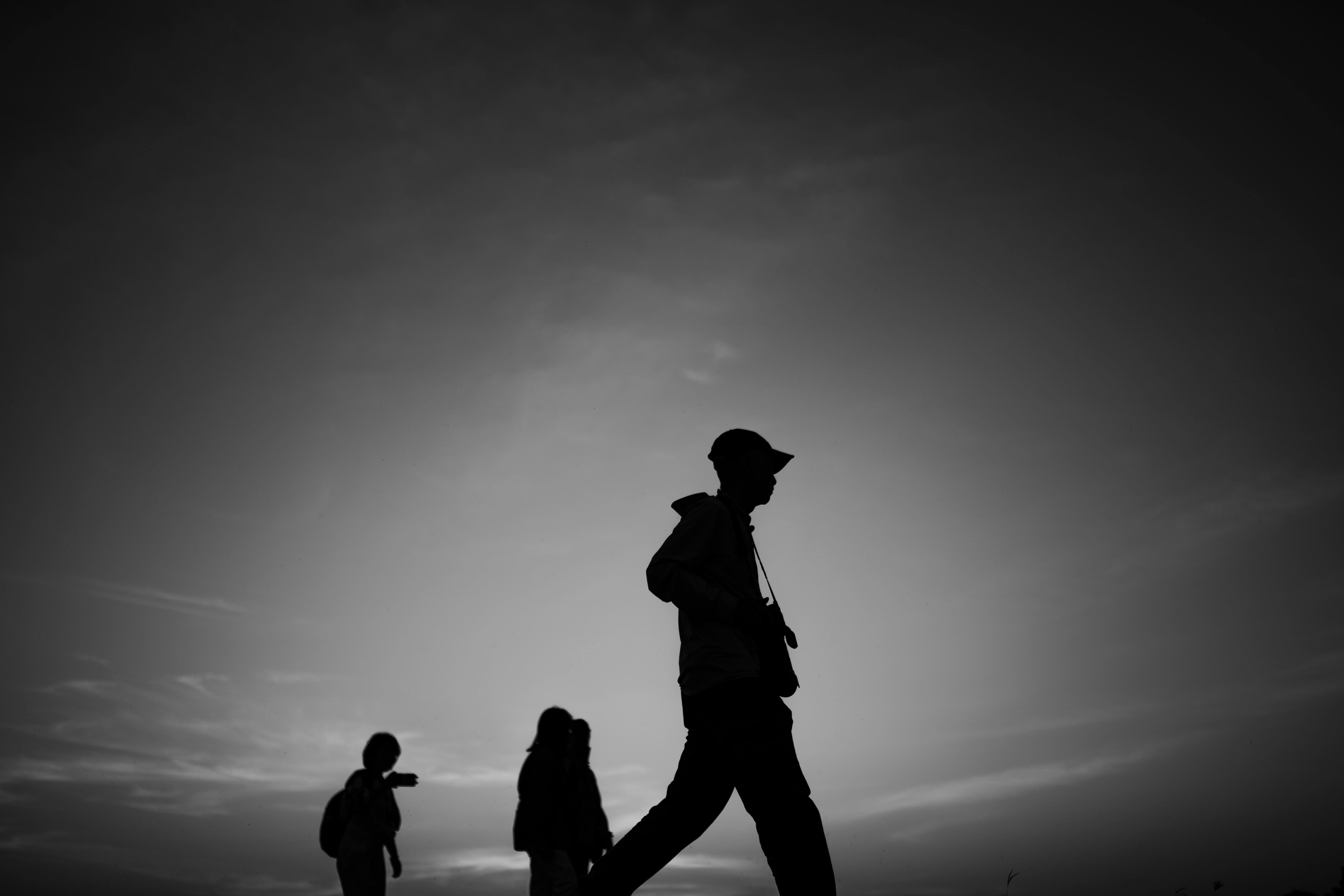 grátis Silhueta artística em preto e branco de viajantes caminhando em Dambulla, capturando a beleza serena do crepúsculo. Foto profissional