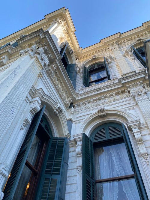 Free Detailed close-up of neoclassical architecture facade with open windows and ornate design. Stock Photo