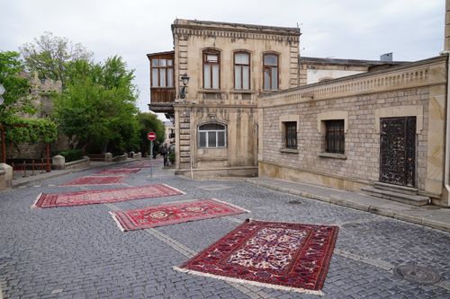 Free A quiet street in Baku with traditional Azerbaijani carpets displayed on the cobblestones. Stock Photo