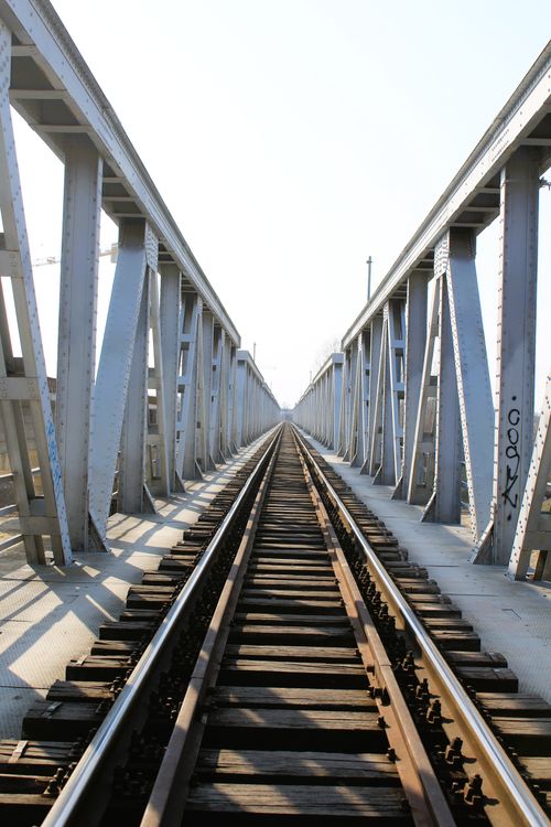 Free A centered view down a long steel railway bridge showcasing symmetry and perspective. Stock Photo