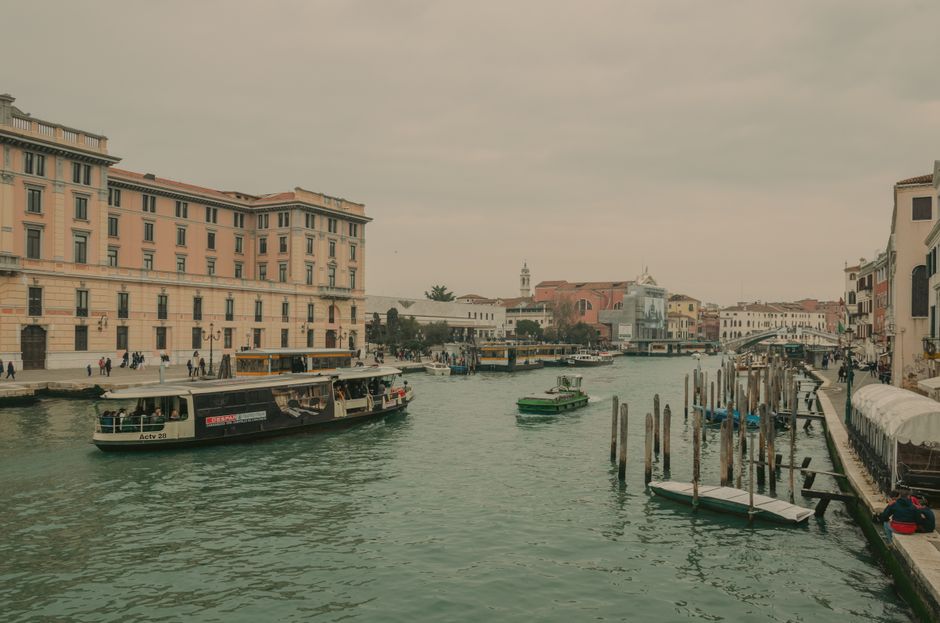 A traditional Venetian gondola gliding along the Grand Canal in Venice, Italy, with historic buildings