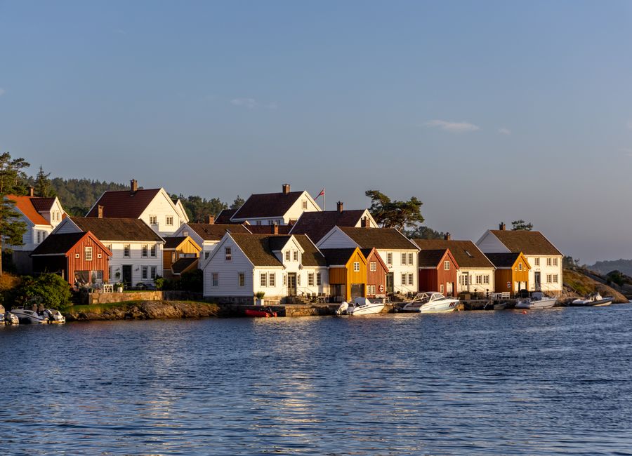Beautiful Norwegian coastal village with colorful houses by the sea during sunset.