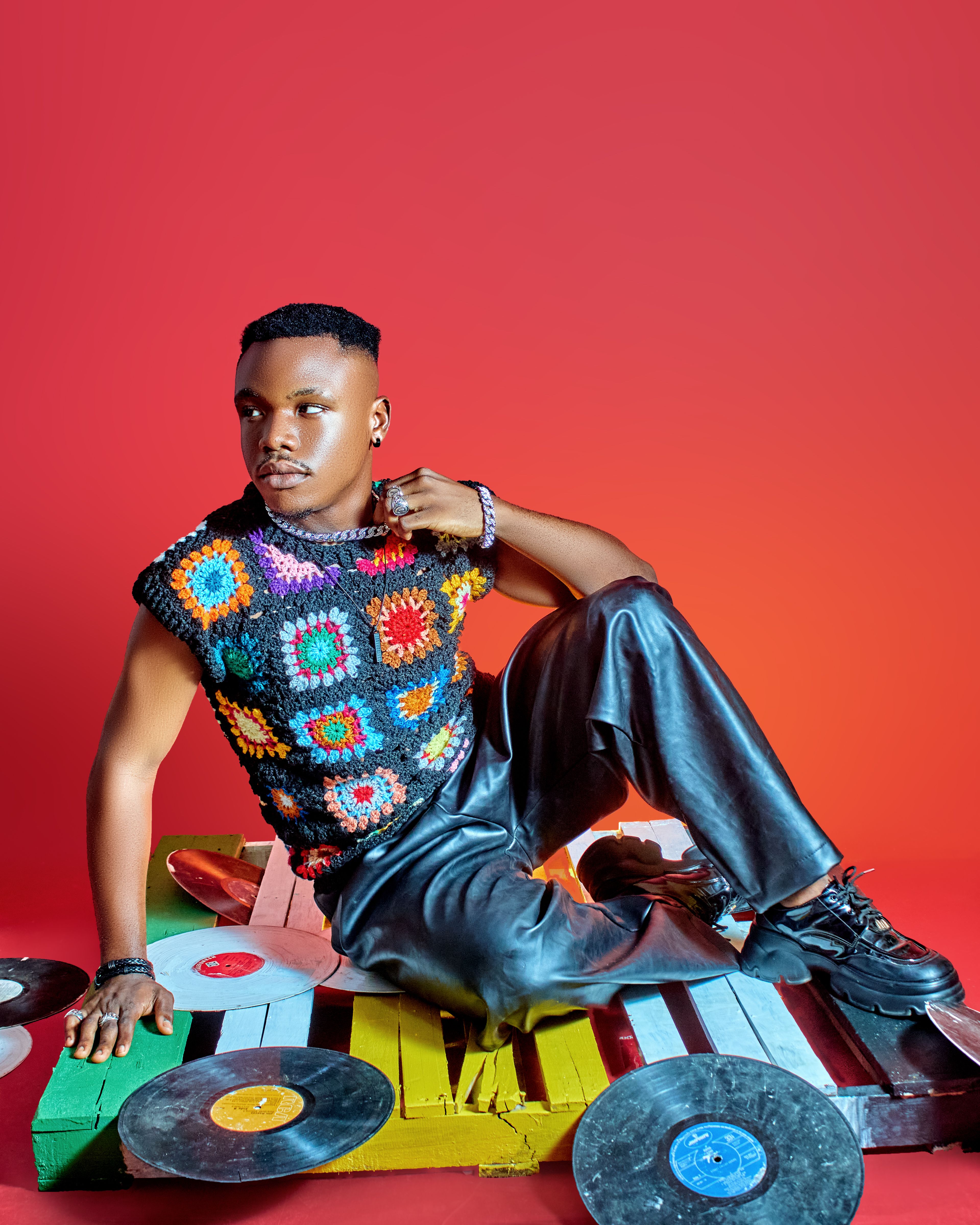 Vibrant photoshoot featuring a black male model in a colorful and artistic studio setting.