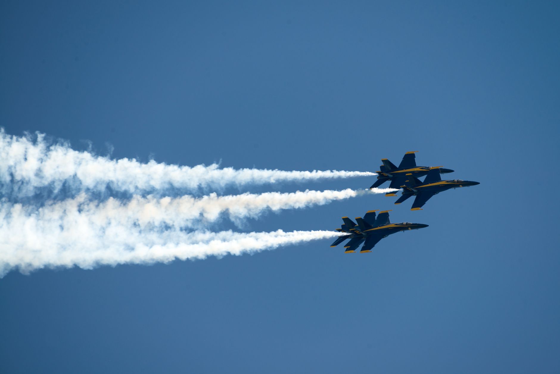 Two Blue Angels jets performing aerobatic maneuvers in clear blue sky over Fairfield, CA.