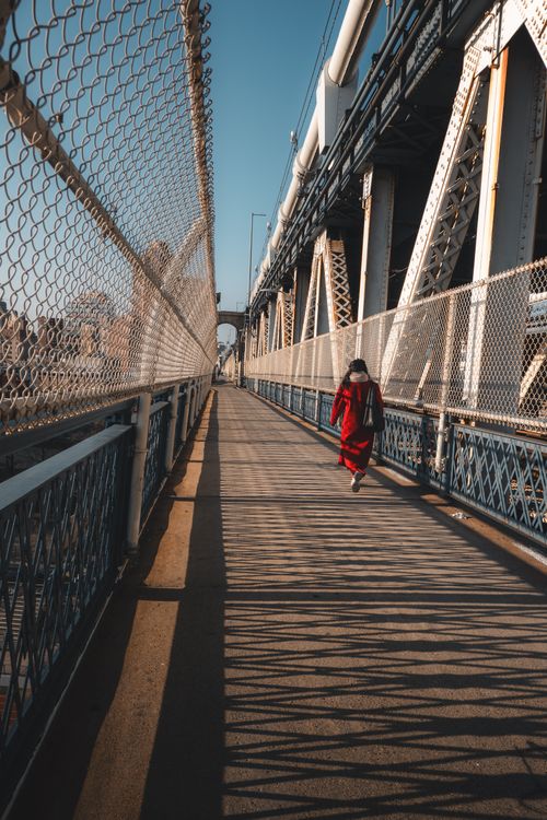Free A person walking on the Manhattan Bridge walkway in New York City during the day. Stock Photo