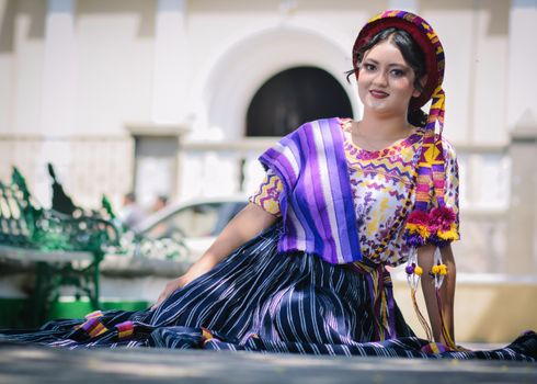 A woman in colorful traditional Guatemalan clothing posing outdoors in Ciudad de Guatemala.
