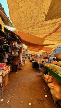 Vibrant market scene showcasing fresh produce under yellow canopies.