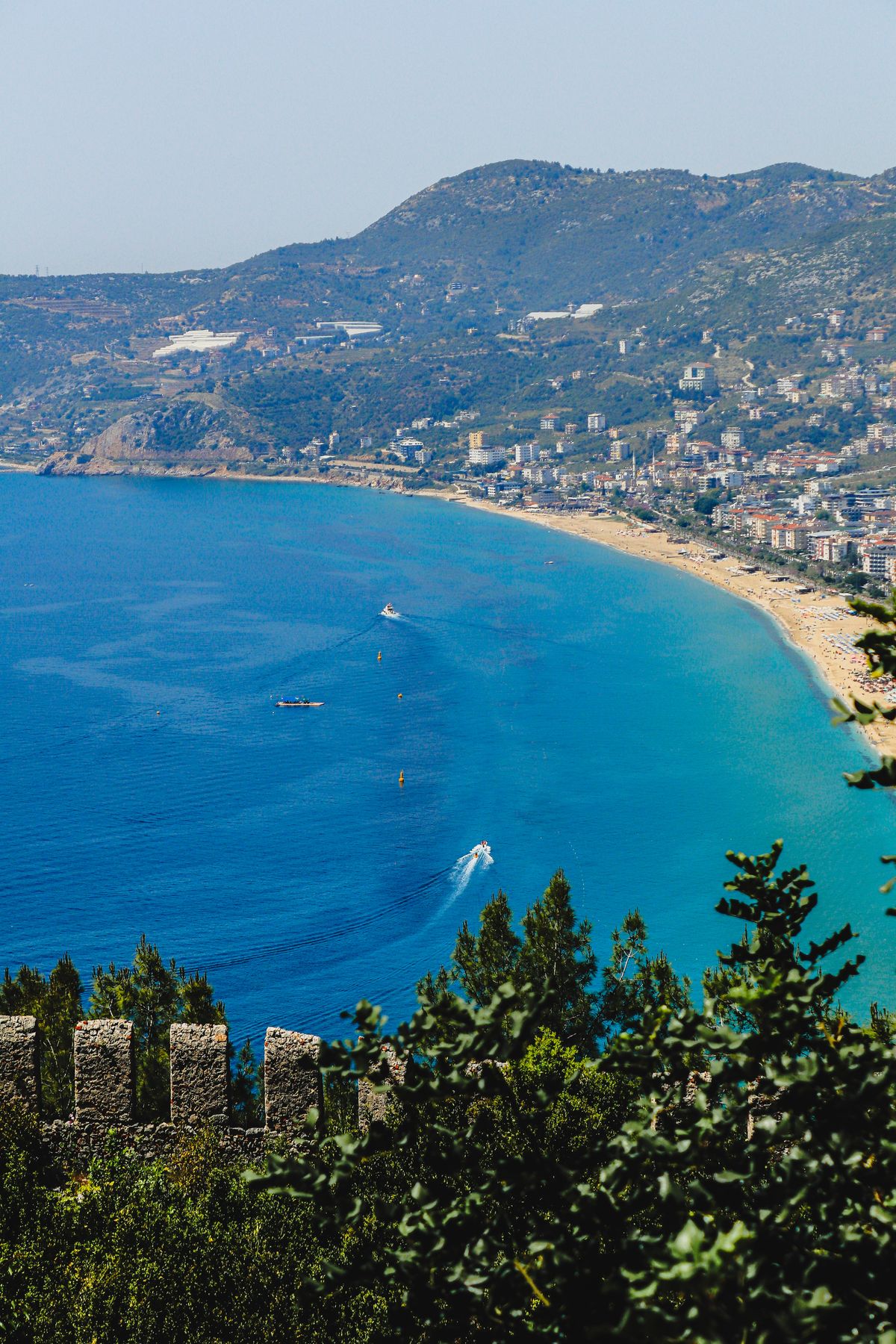 Alanya sahili, uzun kumlu plaj ve tepedeki tarihi Alanya Kalesi'nin panoramik görünümü