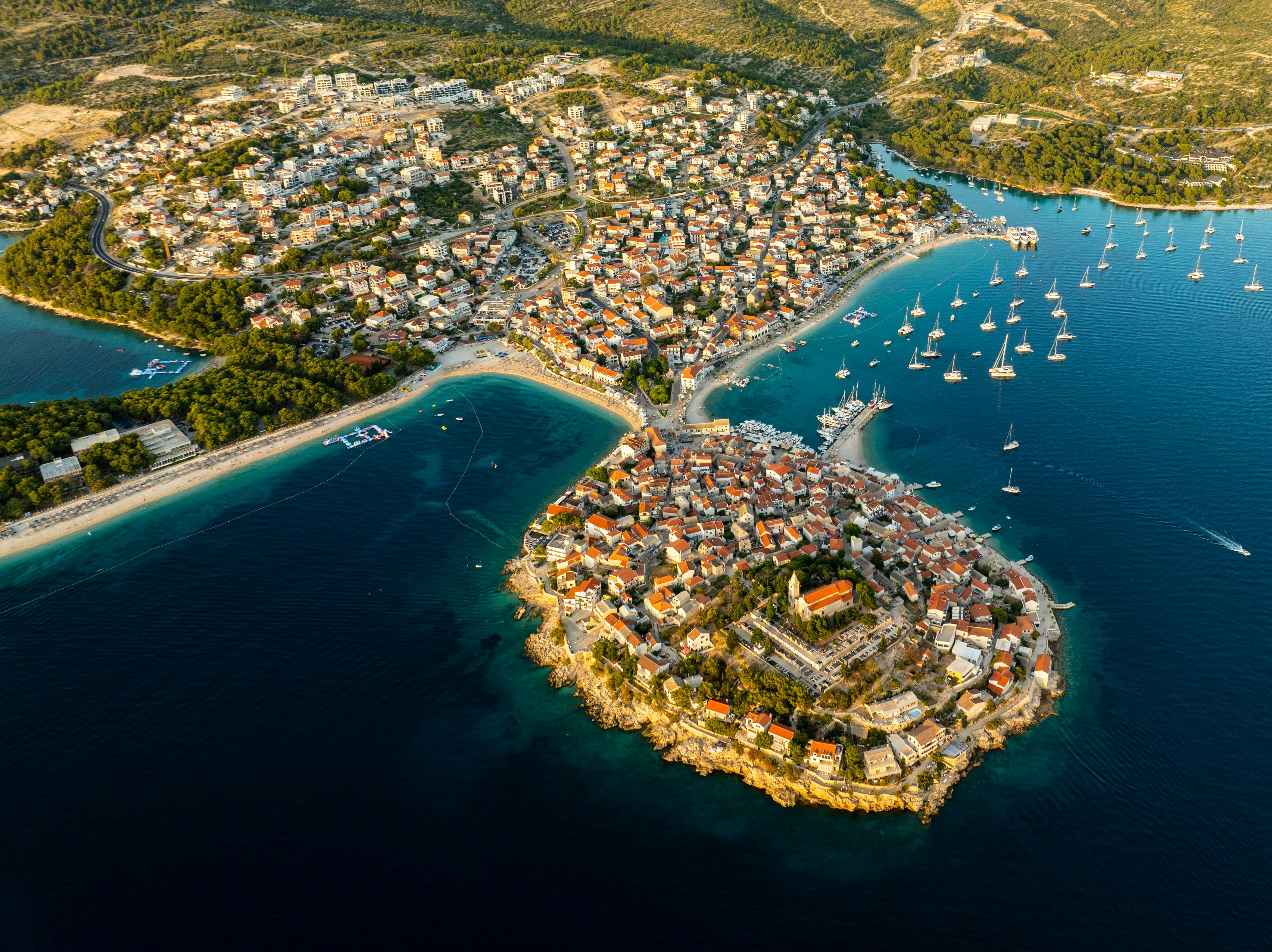 Stunning aerial view of Primošten, Croatia, showcasing vibrant rooftops and serene blue waters with yachts.