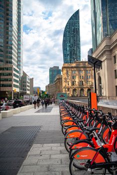 Bicycle rental station in downtown Toronto with modern skyscrapers and historic architecture in view.