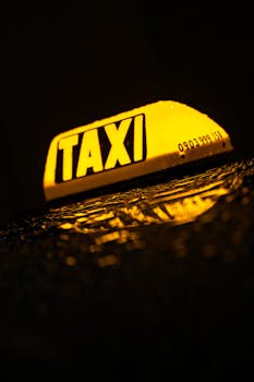 A glowing taxi sign reflected on a wet surface at night in Bratislava, Slovakia.