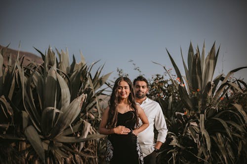 Man and Woman Standing in Middle of Plant Field