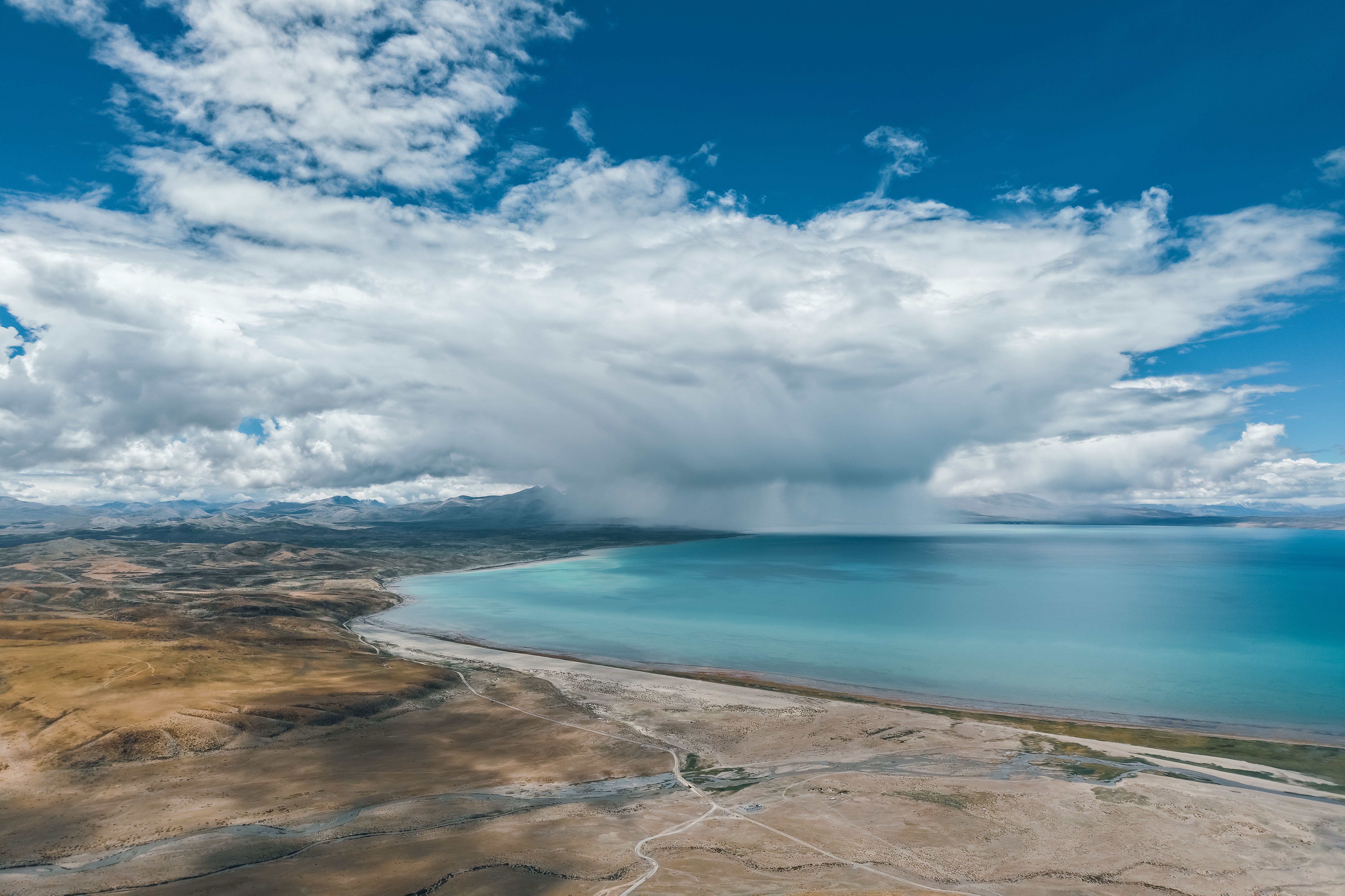 Namtso Lake turquoise high-altitude sacred waters reflecting Nyainqêntanglha snow peaks at sunrise on Tibetan Plateau