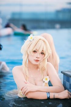A woman in cosplay with floral accessories relaxes in a pool.