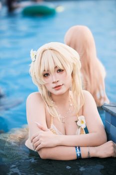 Cosplayer in a detailed costume enjoying a sunny day in a pool.