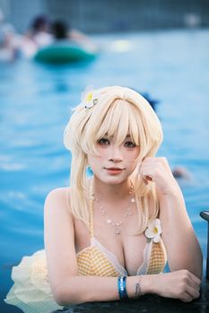 Blonde woman in cosplay costume posing in a swimming pool with a calm expression.