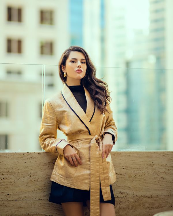 Woman in gold blazer with black dress