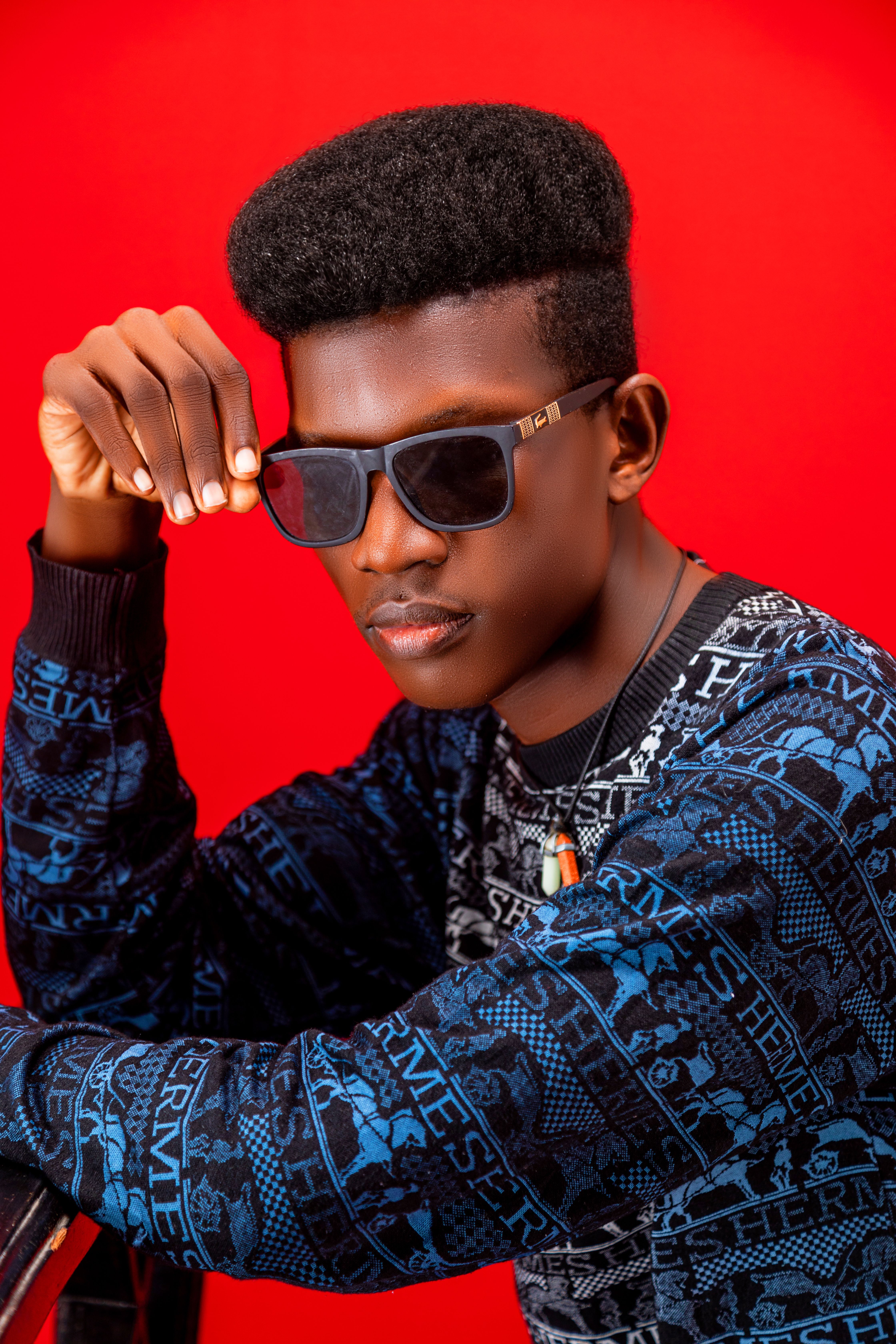 Portrait of a fashionable man wearing sunglasses and a patterned sweater.