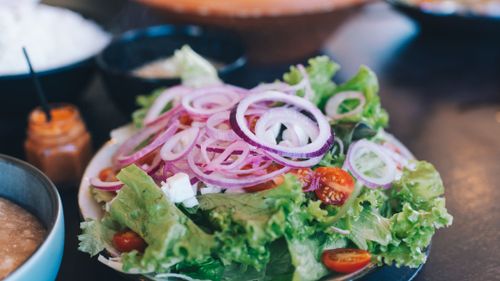 Free Colorful salad with lettuce, onions, tomatoes, and feta cheese, perfect for a healthy meal. Stock Photo