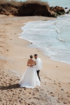 A couple shares a romantic moment on a sandy beach during their spring wedding.