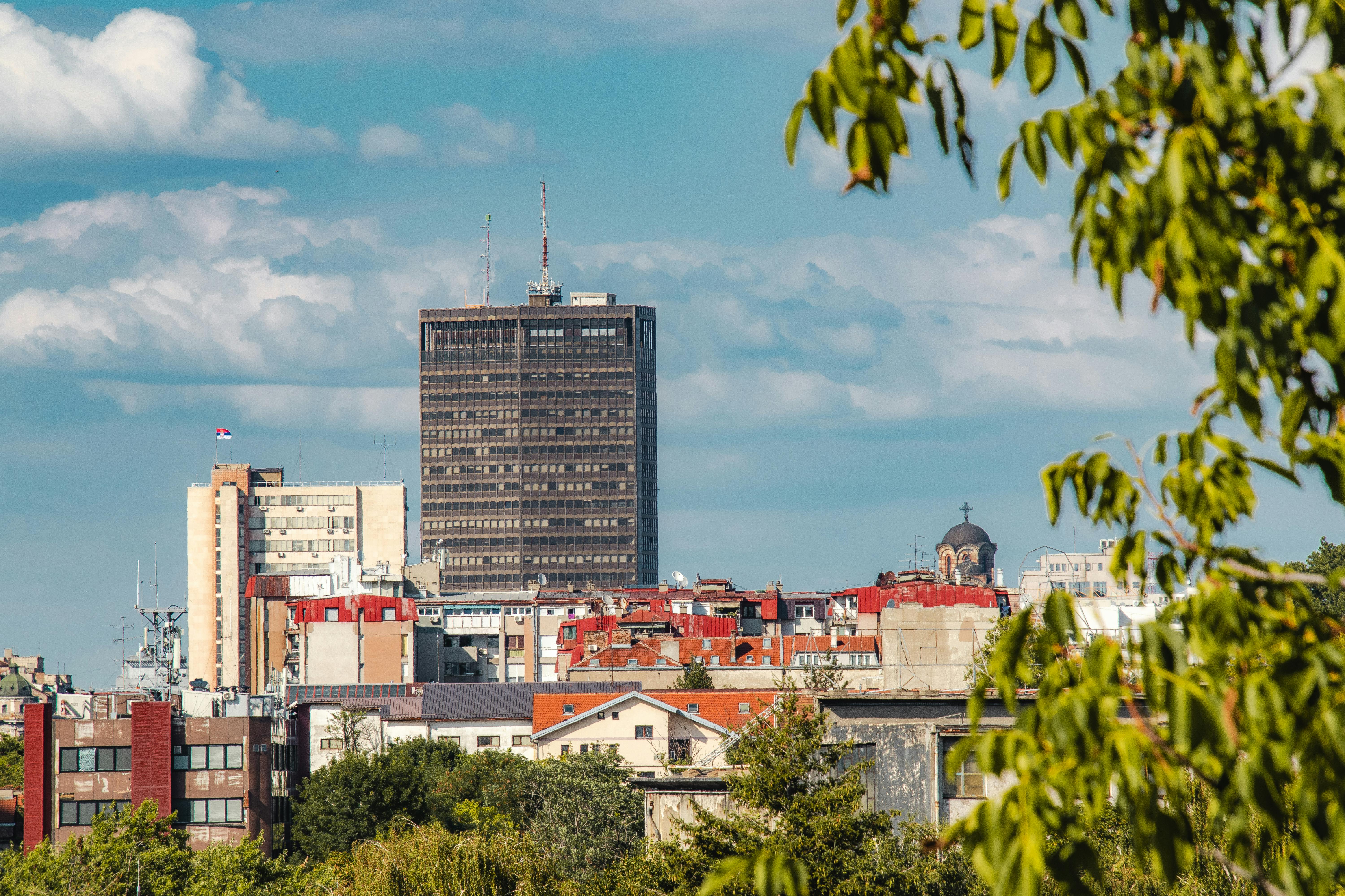 Skyline view of Belgrade with a mix of modern and classic architecture under a bright sky.