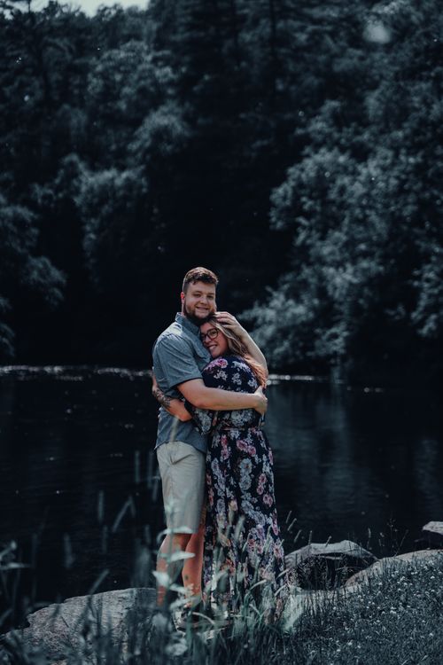 Romantic Couple Embracing by a Serene River · Free Stock Photo