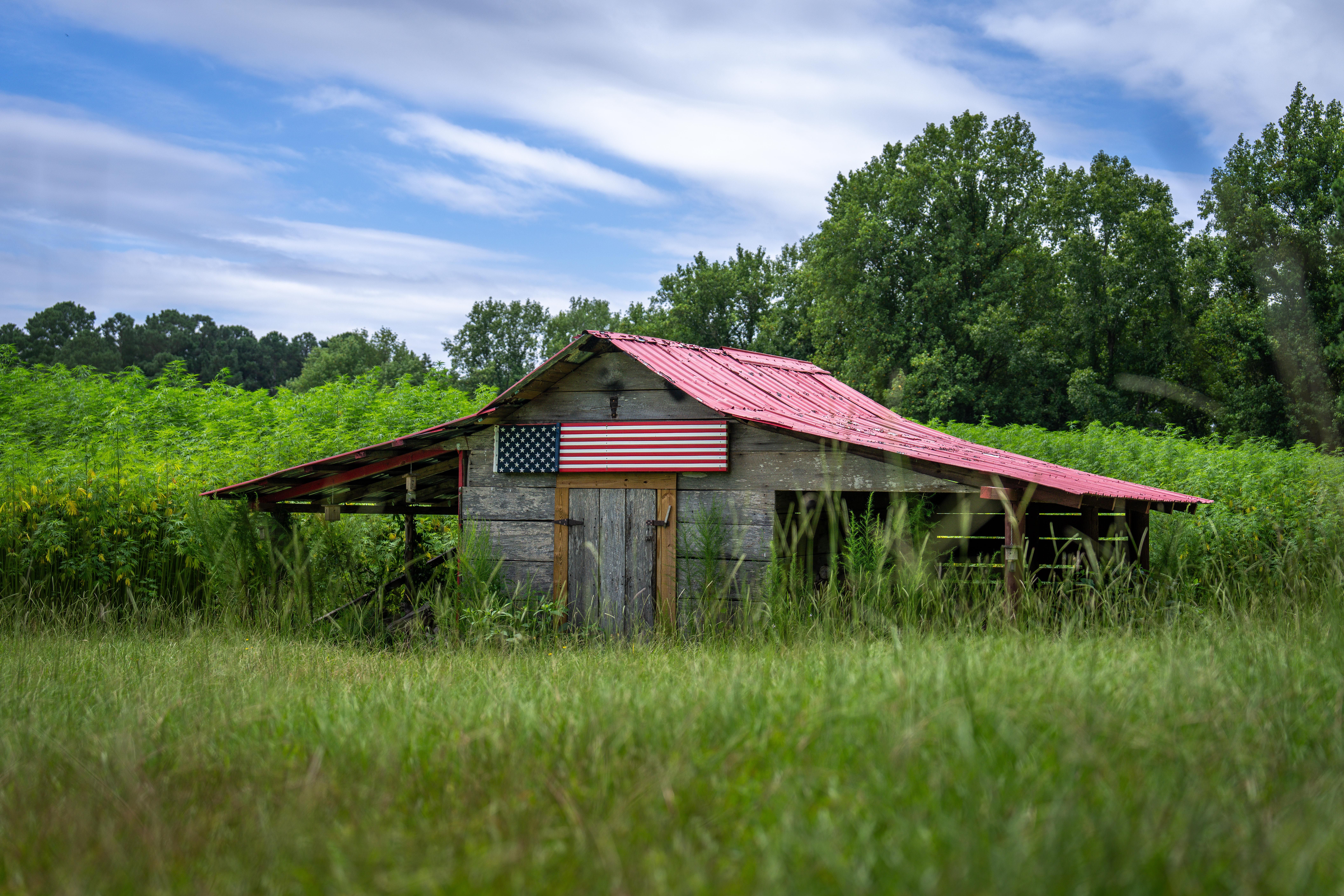 Rural Barn with American Flag in Summer Field · Free Stock Photo