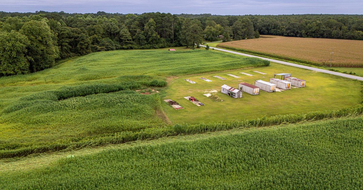 Aerial view of a rural farmland featuring storage containers and fields.