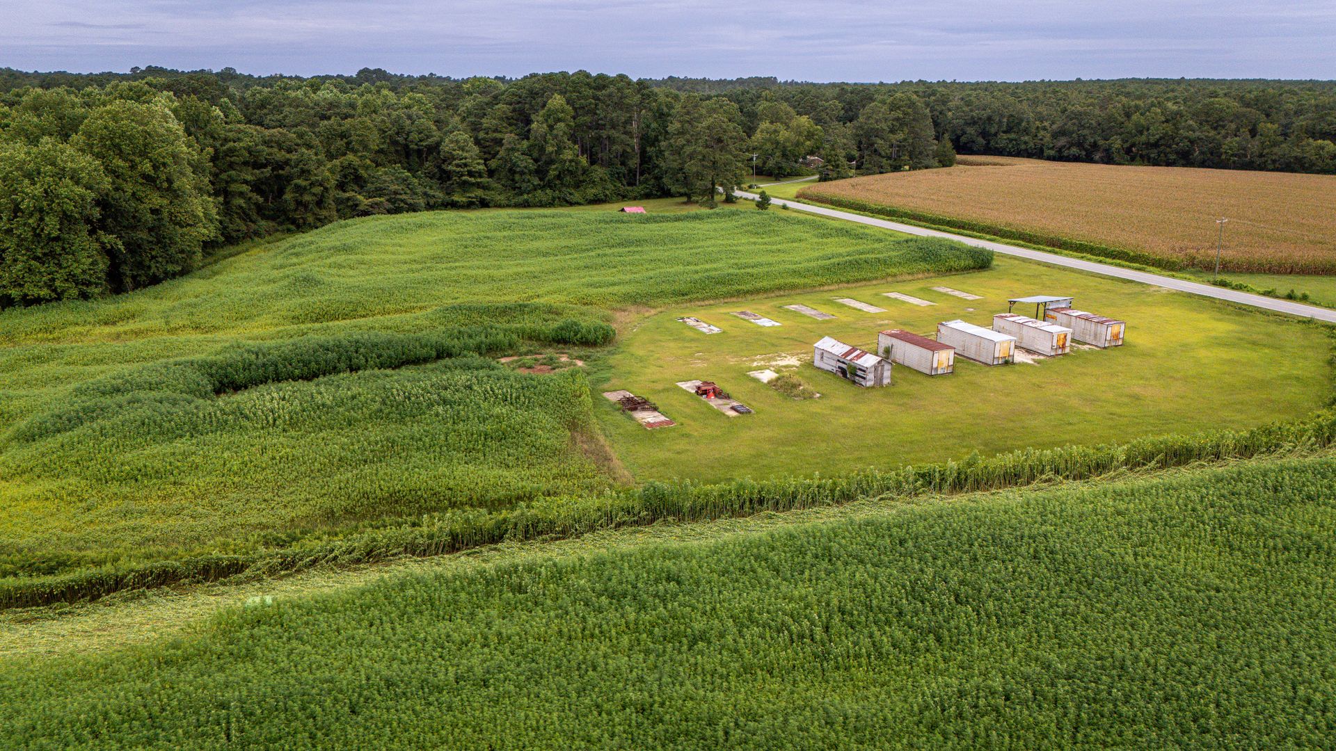 Aerial view of a rural farmland featuring storage containers and fields.