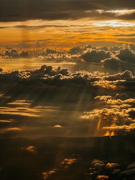 Breathtaking view of a golden sunrise over clouds from a plane, highlighting nature's beauty.