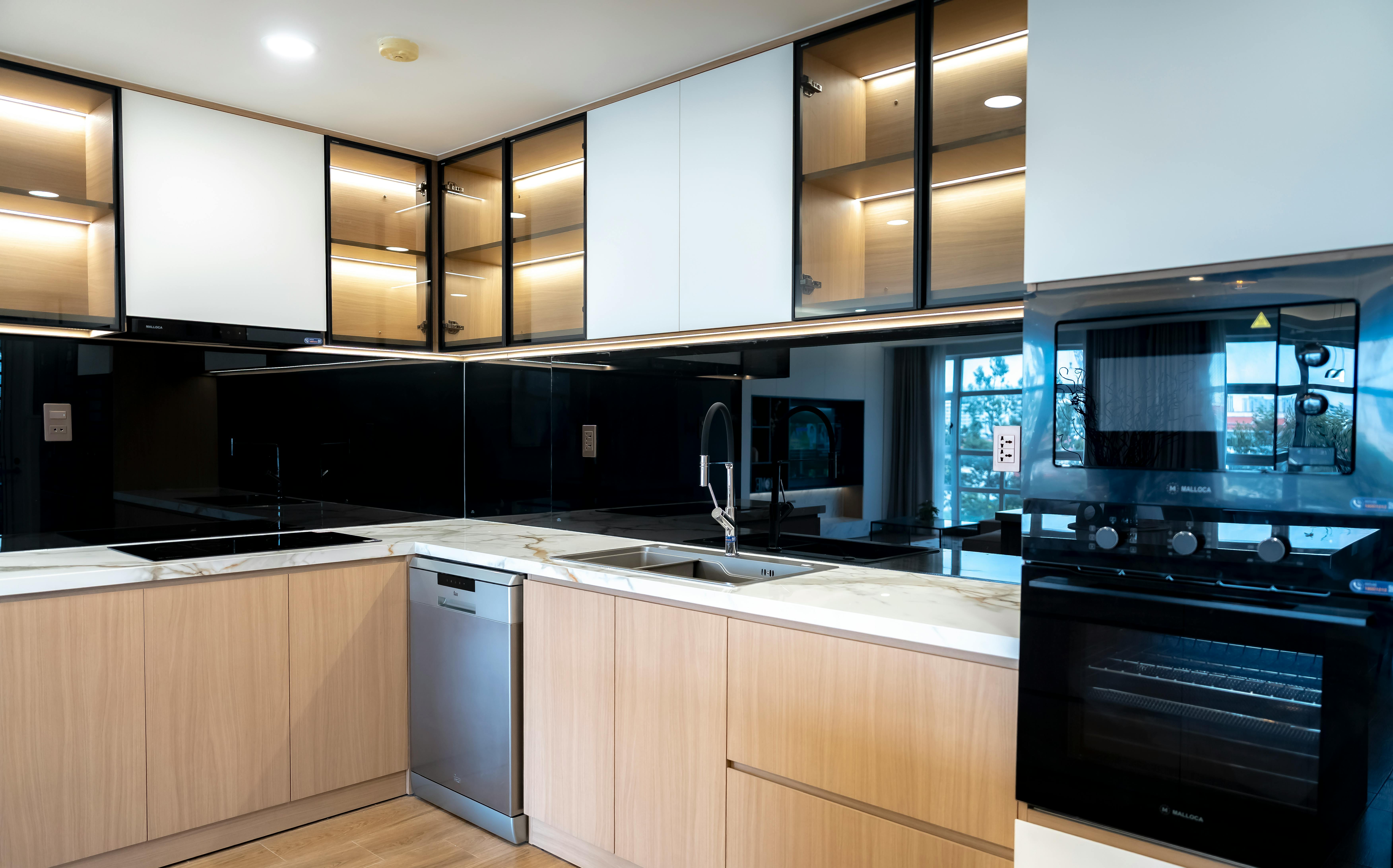 Vollintegrierter Geschirrspüler unter Arbeitsplatte in weißer Einbauküche mit Sockelblende