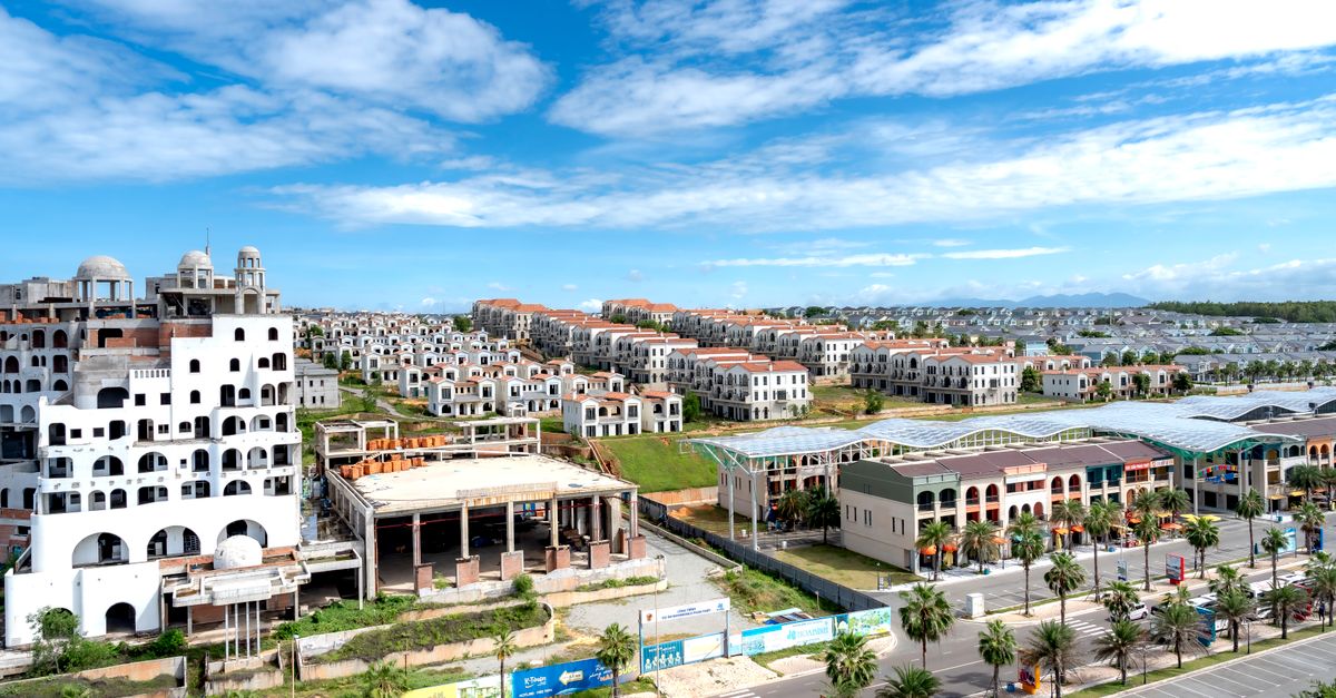 Aerial shot of a sprawling modern residential area under a bright blue sky.