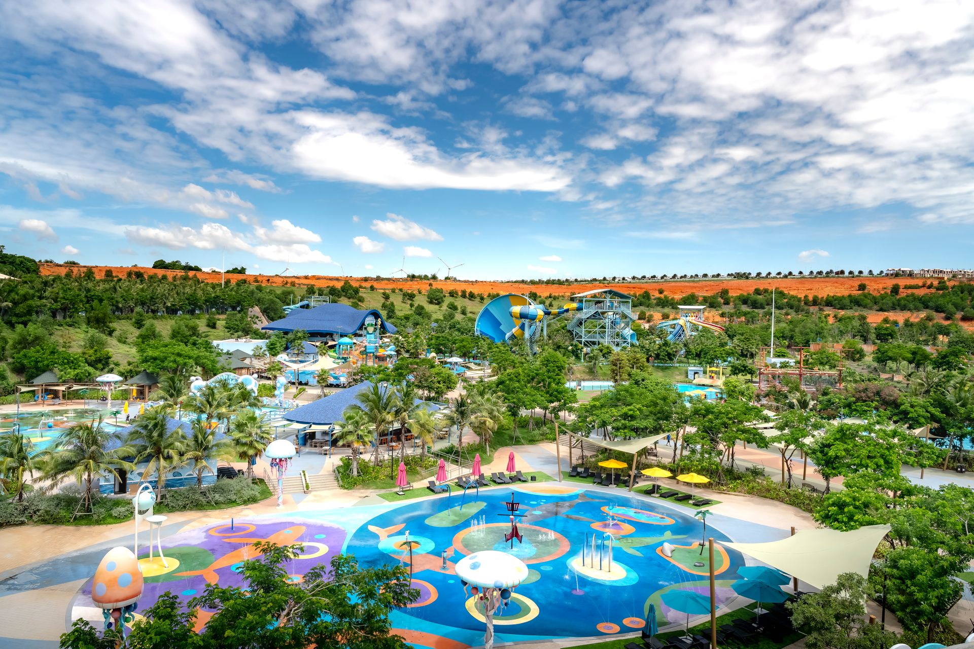 A colorful water park with slides and trees on a sunny day, perfect for family fun.