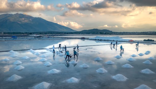 Workers harvesting salt in a stunning landscape at sunrise.