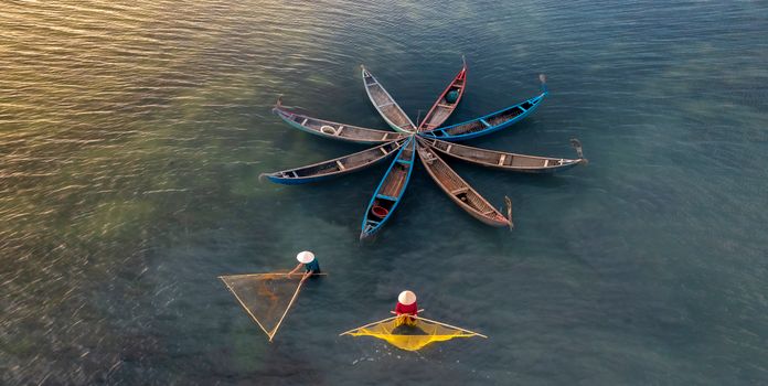 Aerial shot of fishermen with traditional boats and nets creating a unique star pattern on the water.