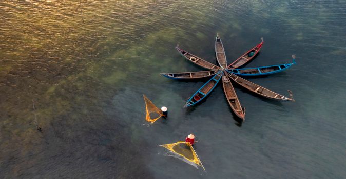 A stunning aerial view of wooden boats forming a star pattern with fishermen.