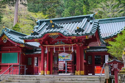 Free A serene view of a traditional Japanese temple surrounded by lush greenery. Stock Photo