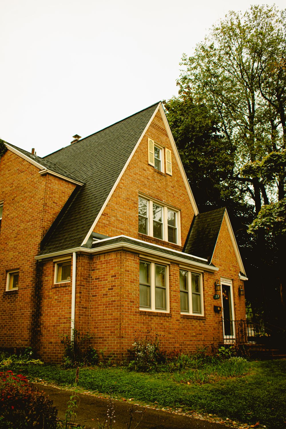 Brick residential home with a steep architectural shingle roof