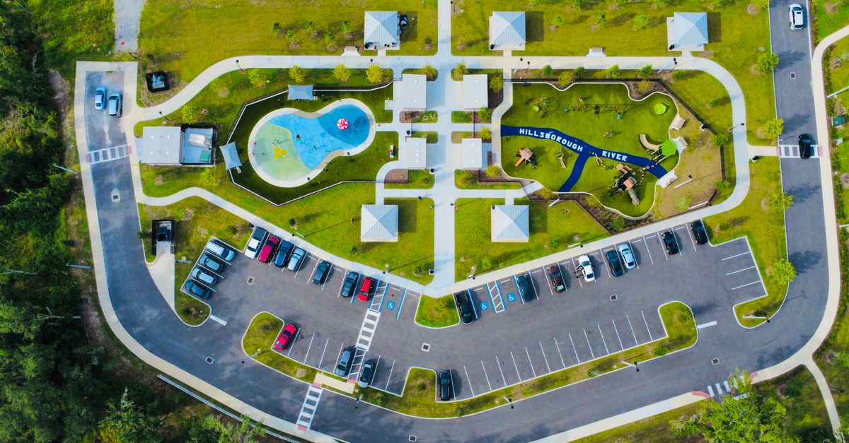 Aerial view of a park with playground, pools, and parking in Florida.