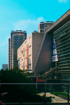 Vibrant city scene featuring modern high-rise buildings under a blue sky.