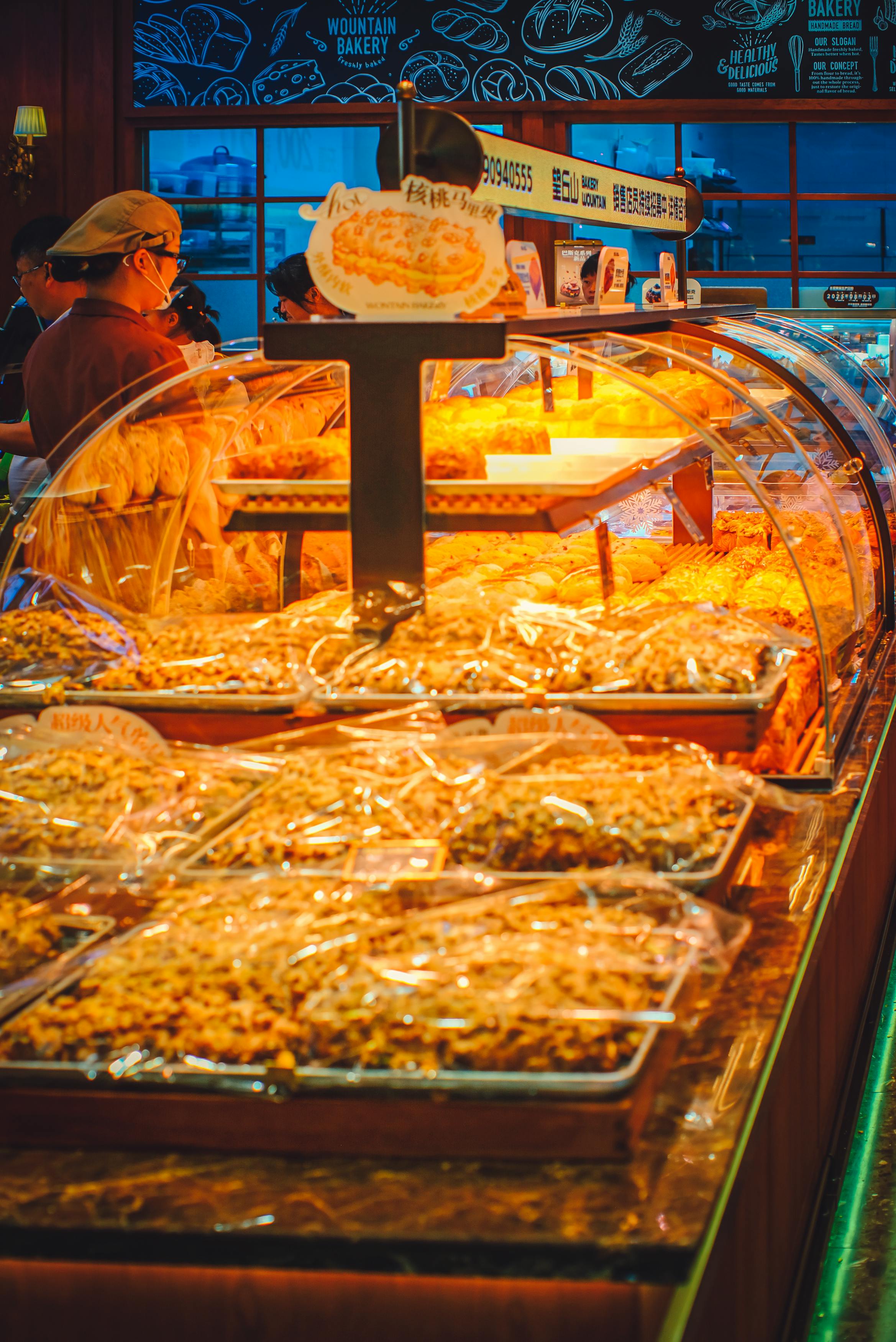 A warm bakery ambiance showcasing fresh pastries and breads under bright lighting.
