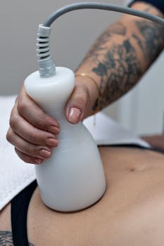 A tattooed therapist performs a body contouring procedure on a client's abdomen in Belo Horizonte.