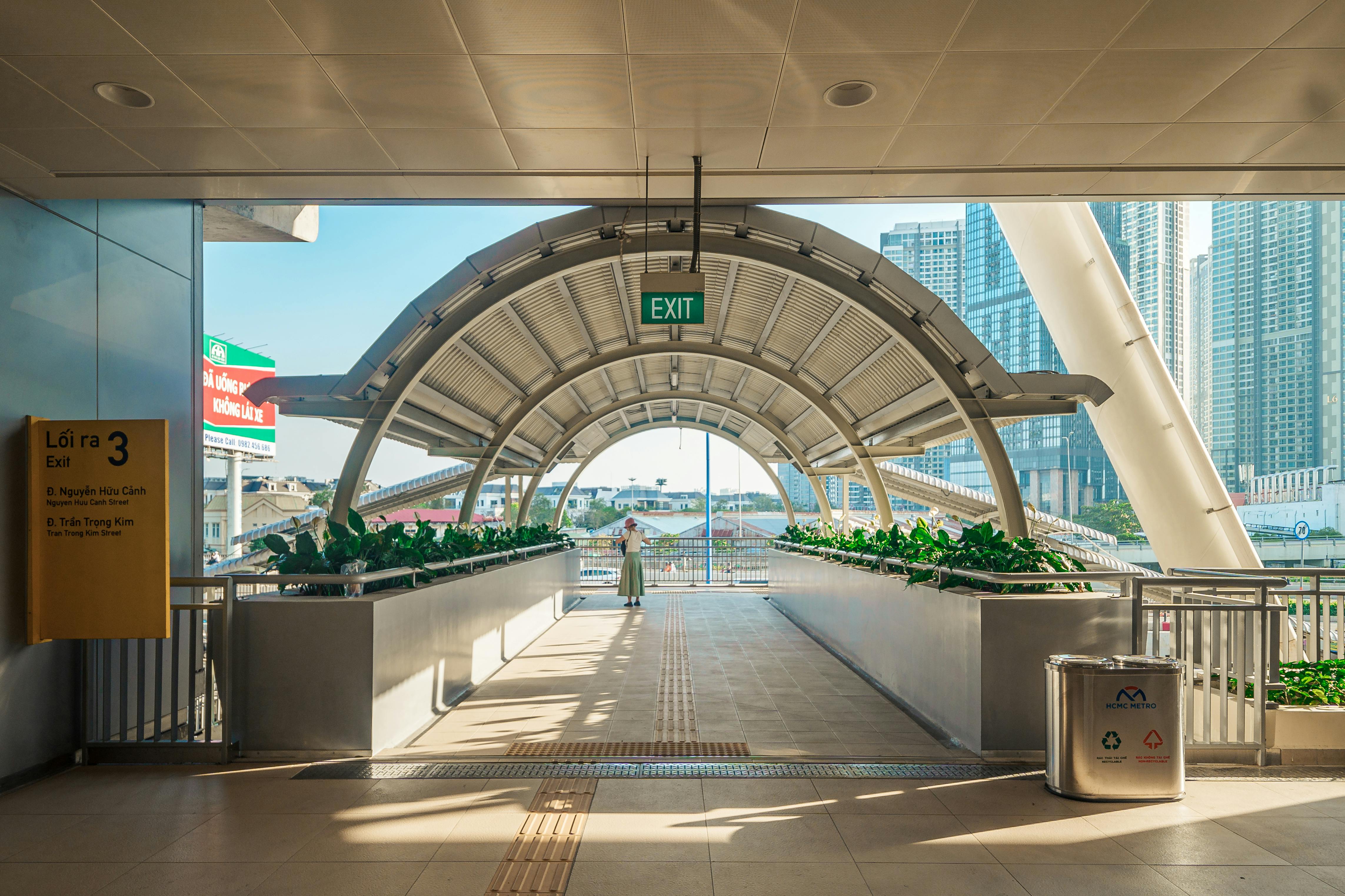 Modern walkway with cityscape in Ho Chi Minh City, featuring architectural details and green plants.