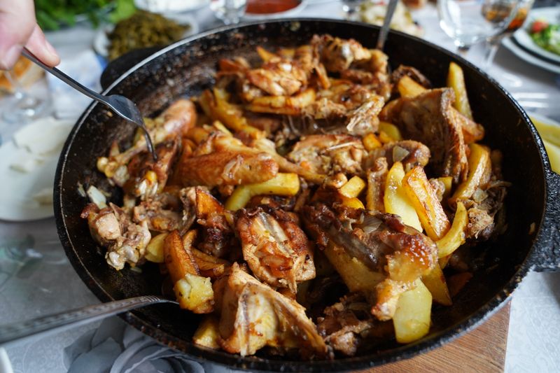 Savoury roasted chicken and potato dish served in a large skillet, perfect for family gatherings.