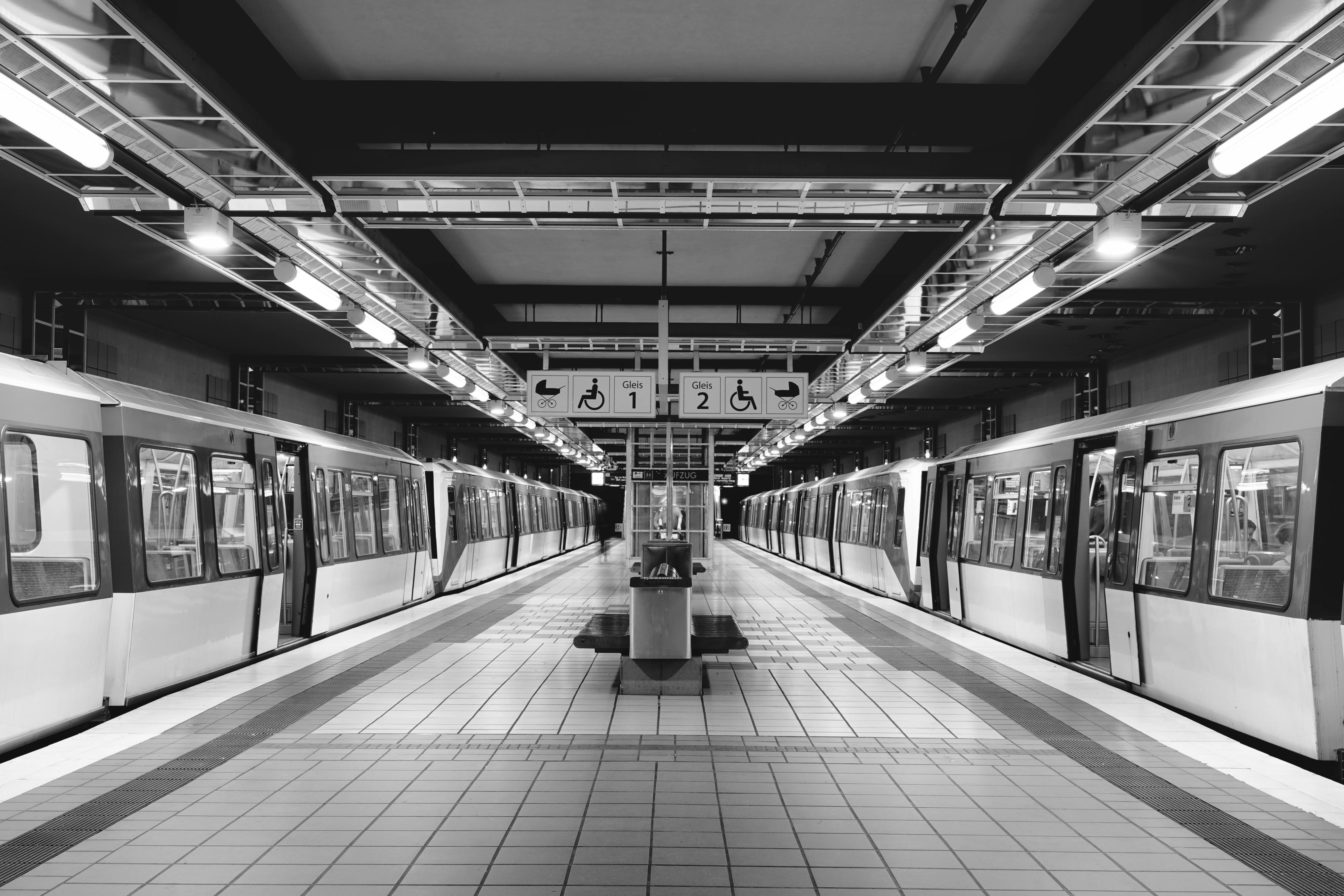 Monochrome view of a deserted train station in Hamburg with empty platforms and trains.