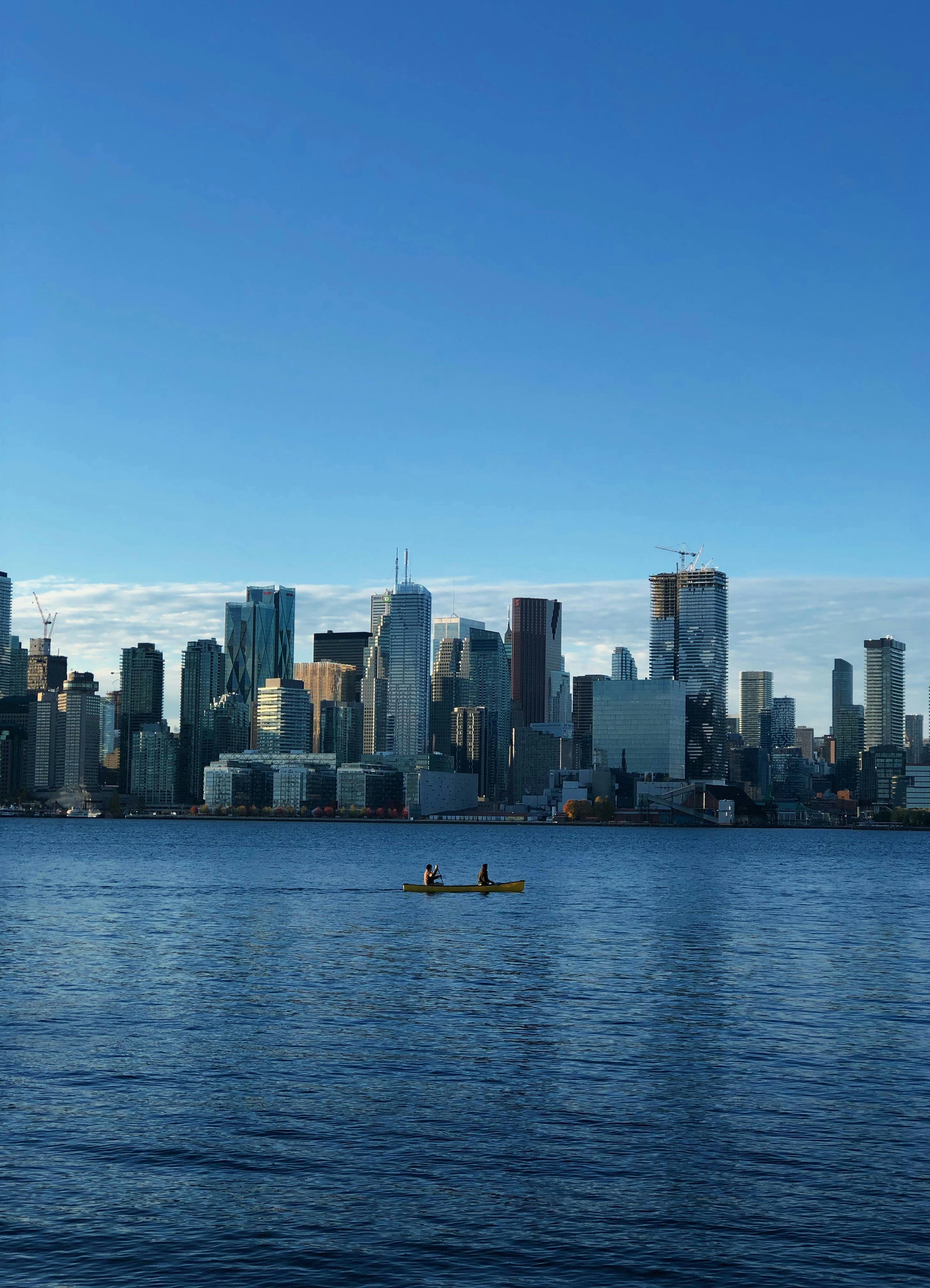 Canoeists on Lake Ontario with a stunning view of the Toronto skyline at daytime.