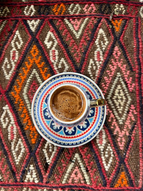Free Authentic Turkish coffee in a decorative cup on a vibrant traditional rug. Stock Photo