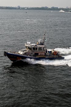 NYPD police boat on patrol in urban waters on a sunny day.