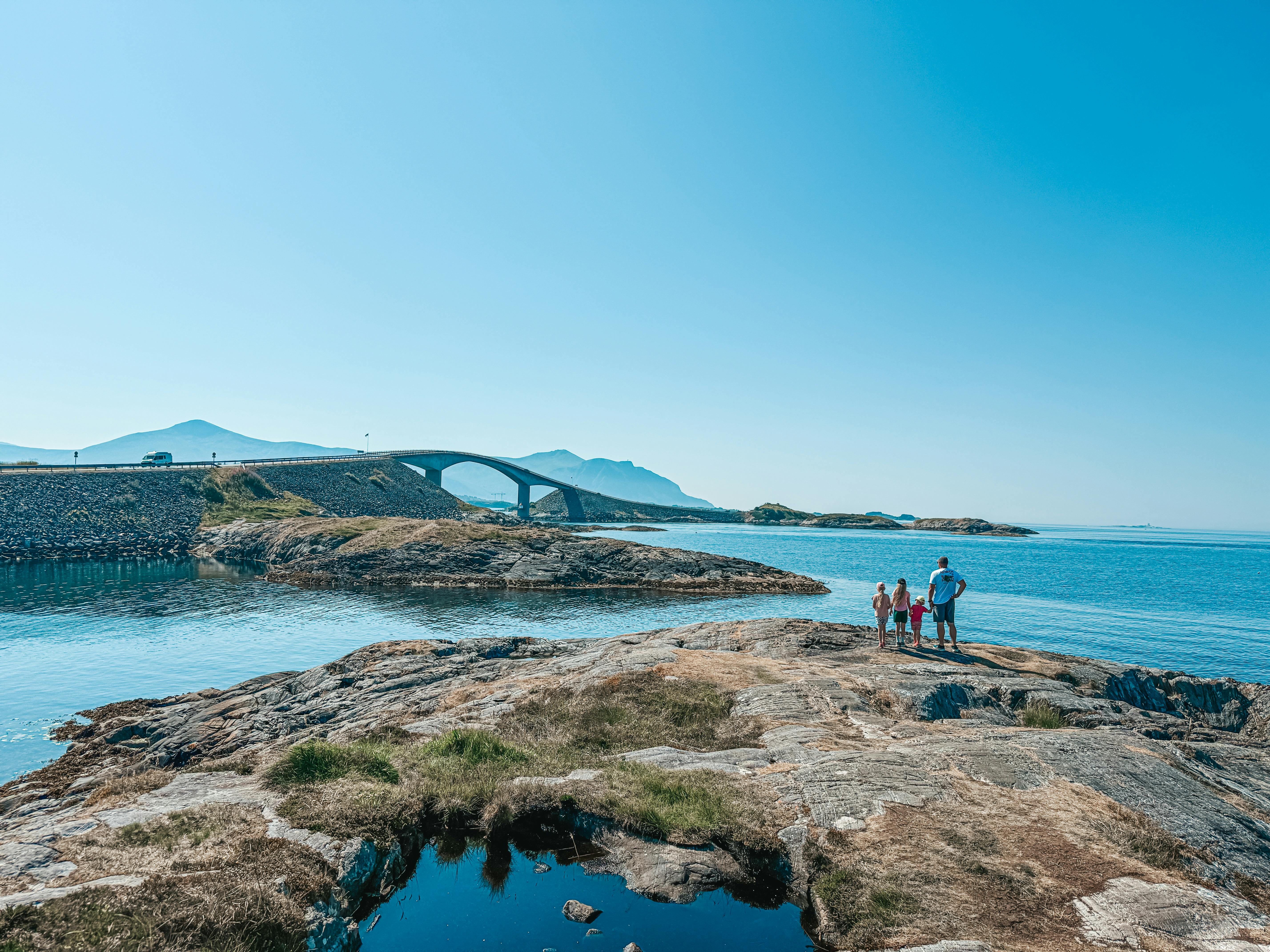 A family enjoys a sunny day by the iconic Atlantic Ocean Road in Norway.